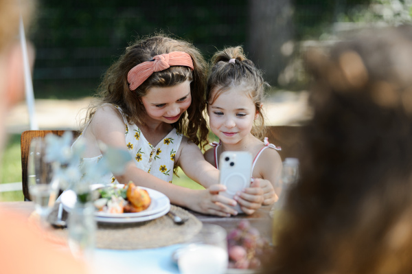 Cousins taking a selfie at a family garden party. Family reunion at a garden barbecue party.