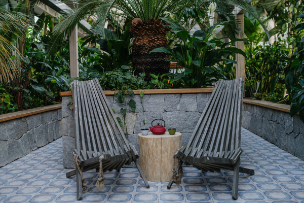 Close up of lounge wooden chairs and side table with tea cups in wellness center. Wellness weekend in spa.