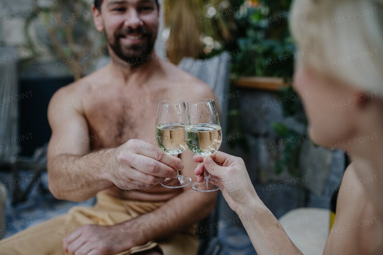 Beautiful couple toasting and drinking champagne, enjoying romantic wellness weekend in spa. Concept of Valentine's Day. Close up.