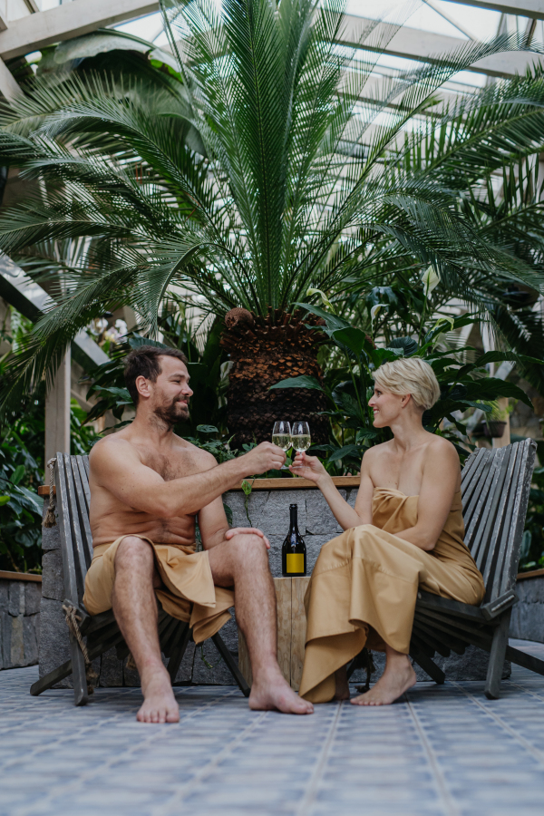 Beautiful couple toasting and drinking champagne, enjoying romantic wellness weekend in spa. Concept of Valentine's Day.