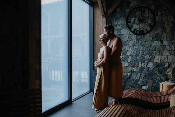 Beautiful couple standing in hotel wellness, enjoying romantic weekend in the spa. Concept of Valentine's Day.