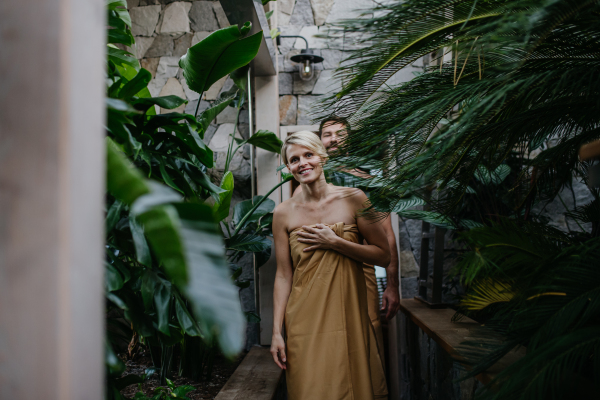 Beautiful couple standing in hotel greenhouse, enjoying romantic wellness weekend in the spa. Concept of Valentine's Day.