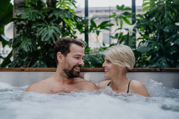 Beautiful mature couple relaxing in the hot tub, enjoying romantic wellness weekend in spa. Concept of Valentine's Day.