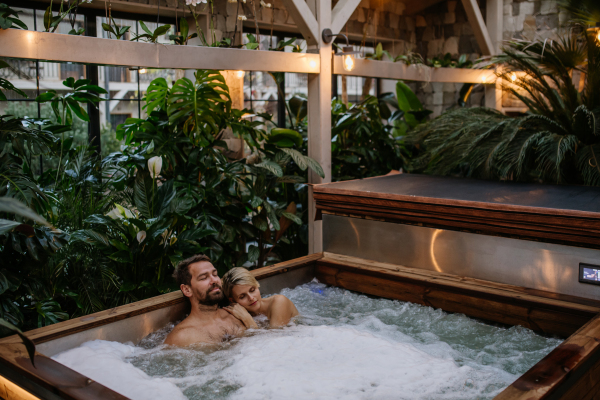 Beautiful mature couple relaxing in the hot tub, enjoying romantic wellness weekend in spa. Concept of Valentine's Day.