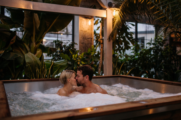 Beautiful mature couple relaxing in the hot tub, enjoying romantic wellness weekend in spa. Concept of Valentine's Day.