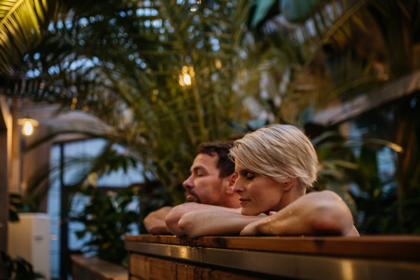 Beautiful mature couple relaxing in the hot tub, enjoying romantic wellness weekend in spa. Concept of Valentine's Day.