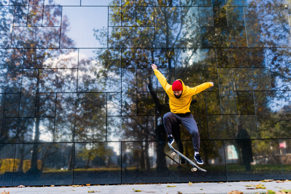 Young man skating outdoors in the city. Stylish skateboarder training in skate park. Concept of skateboarding as sport and lifestyle.