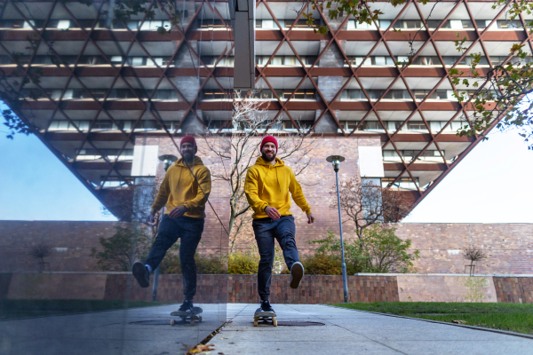 Young man skating outdoors in the city. Stylish skateboarder training in skate park. Concept of skateboarding as sport and lifestyle.