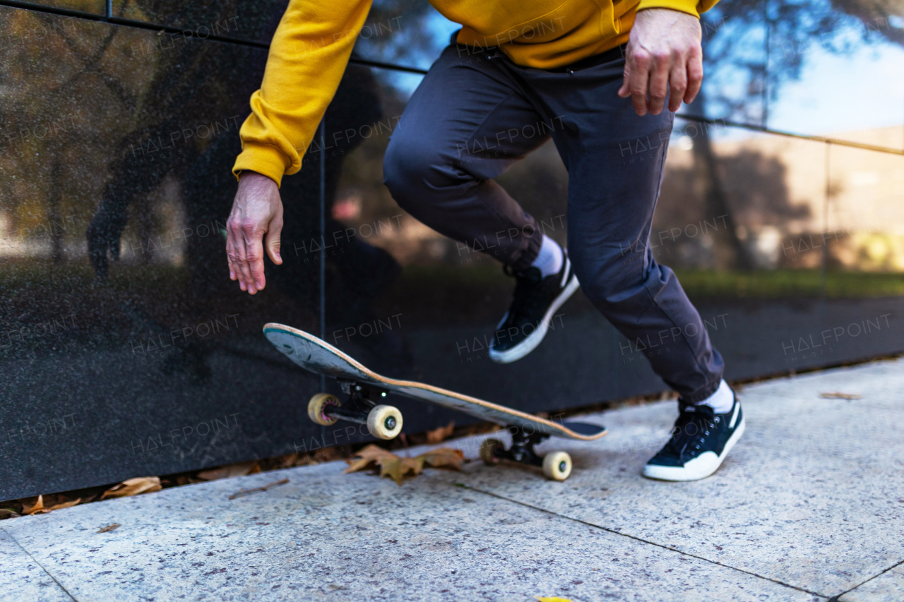 Close up on legs and skateboard of man skating in the city. Stylish skateboarder training in skate park. Concept of skateboarding as sport and lifestyle.