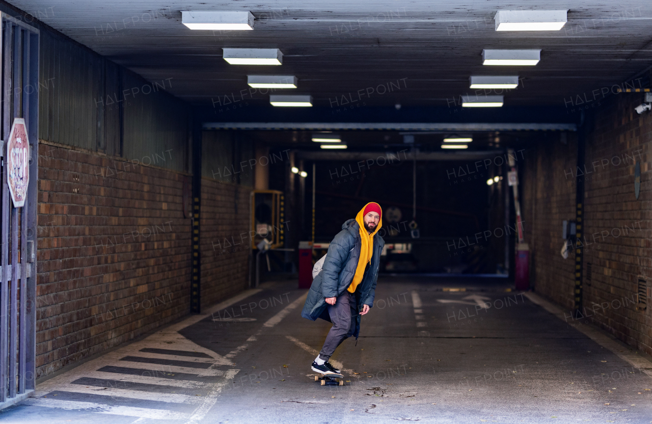 Young man skating outdoors in the city. Stylish skateboarder training in skate park. Concept of skateboarding as sport and lifestyle.