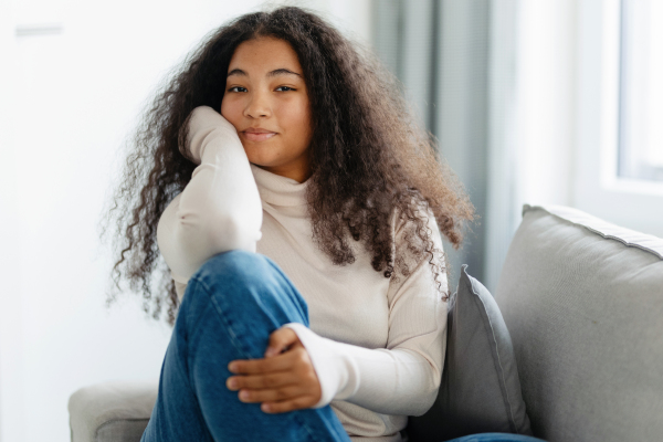 Portrait of beautiful curvy woman in turtleneck, with beautiful curly hair, looking at camera.