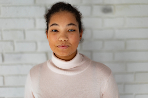 Portrait of beautiful curvy woman in turtleneck, with beautiful curly hair, looking at camera.