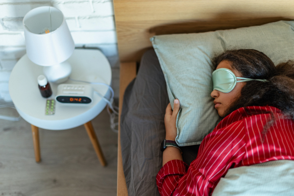 Woman sleeping with sleep mask on the face. Concept of sleep routine. Insomnia a sleep problems among adults.