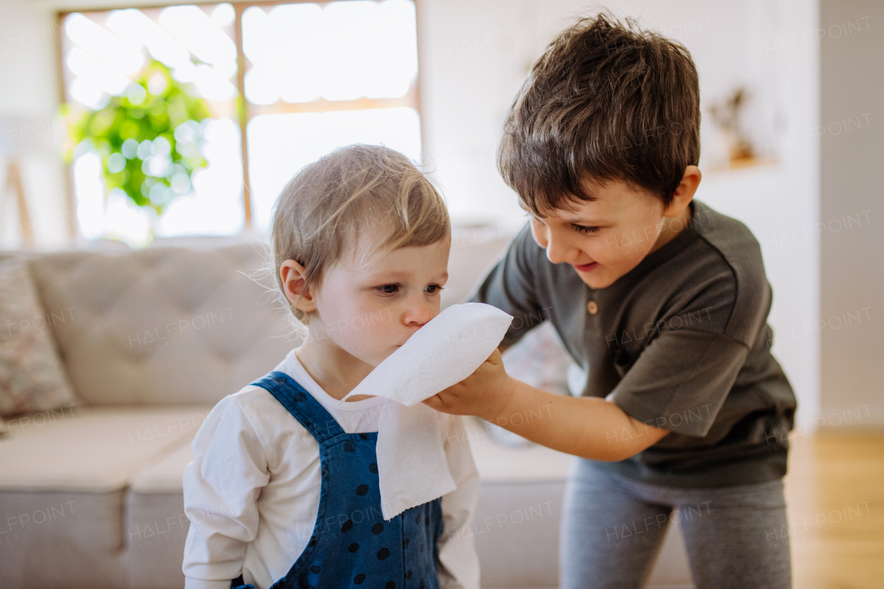 A big brother taking care of his little sister with a cold.