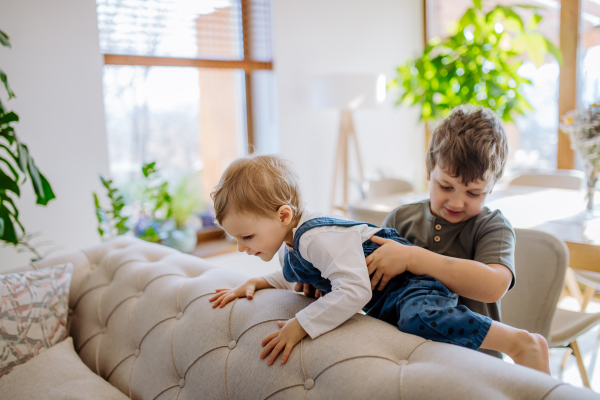 A little siblings playing in living room together.