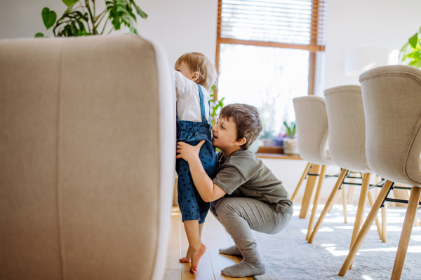 A little siblings playing in living room together.