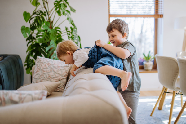 A little siblings playing in living room together.