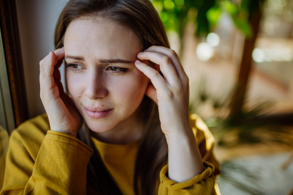 A woman suffering from depression and crying at home.