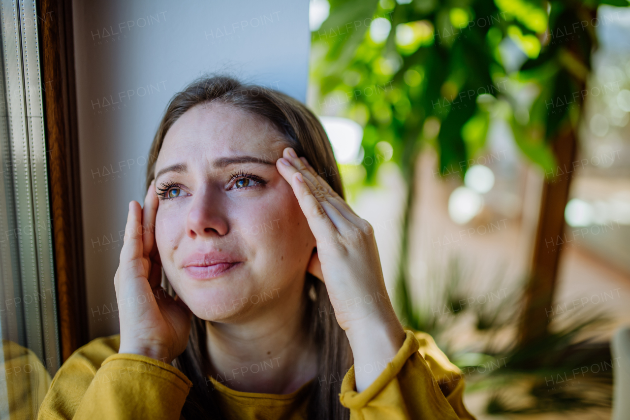 A woman suffering from depression and crying at home.