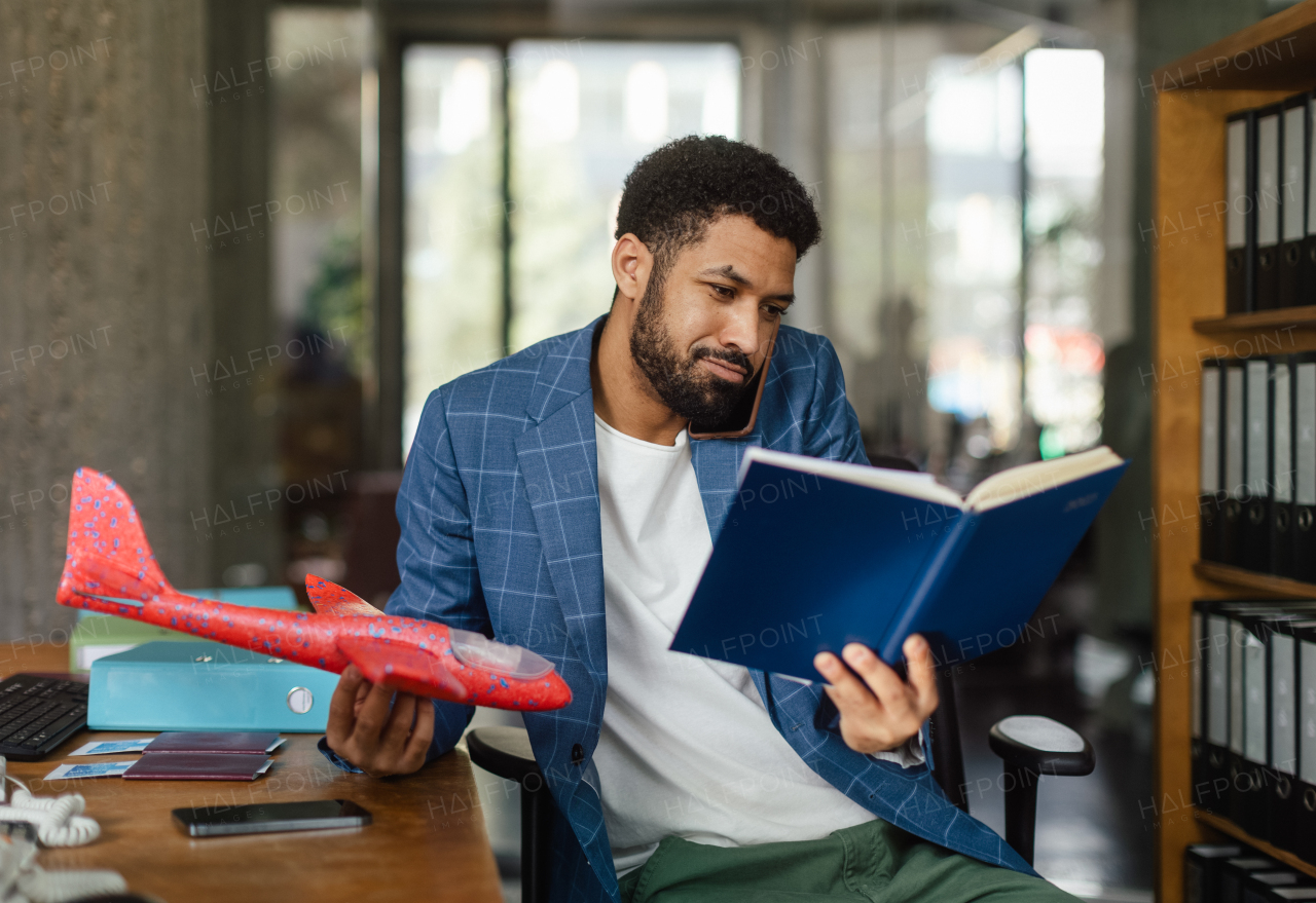 Young happy man holding model of plane in an office.