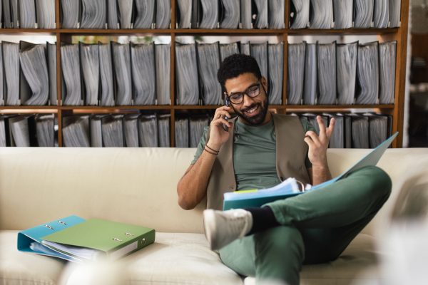 Young multiracial man sitting on a sofa and working.