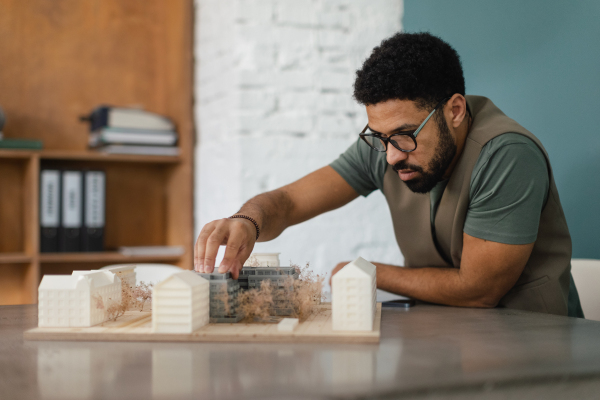 Young multiracial architect designing building in his office.