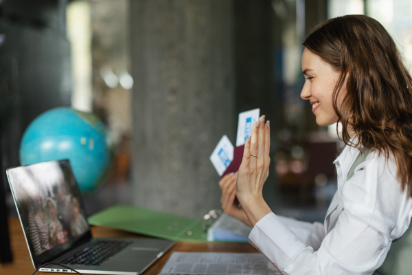 Close up of a young woman holding plane tickets.