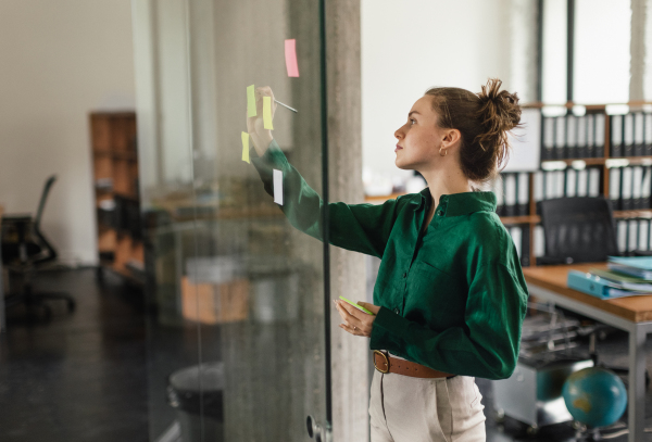 Young woman taking notes in the office.