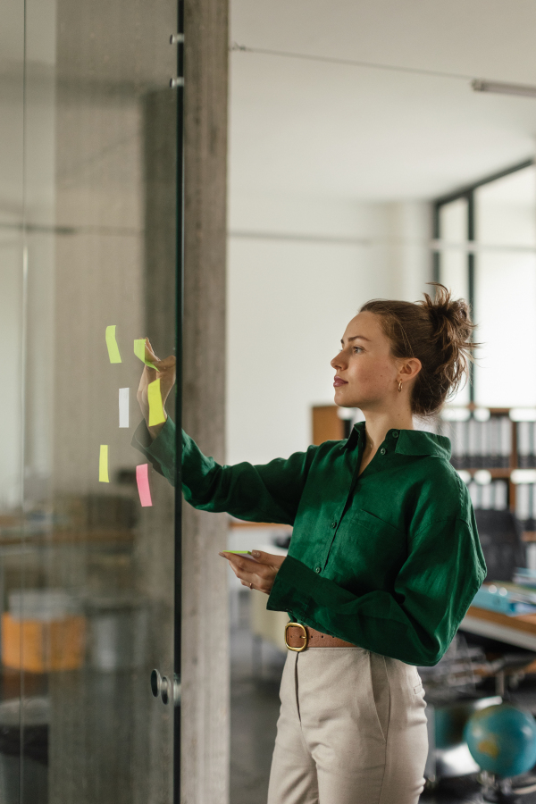 Young woman taking notes in the office. Brainstorming, mind mapping techniques.