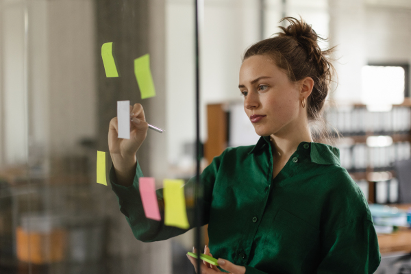 Young woman taking notes in the office.