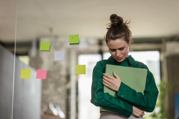 Young sad woman in office, having troubles.