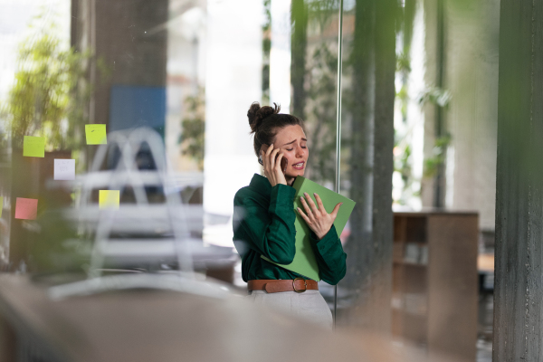 Young sad woman in office, having troubles.