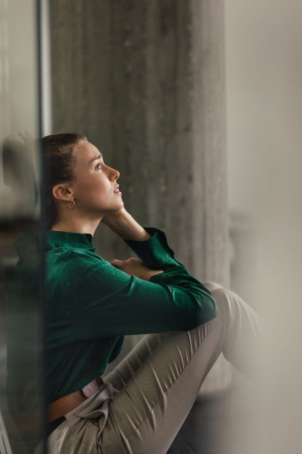 Young sad woman in office, having troubles.