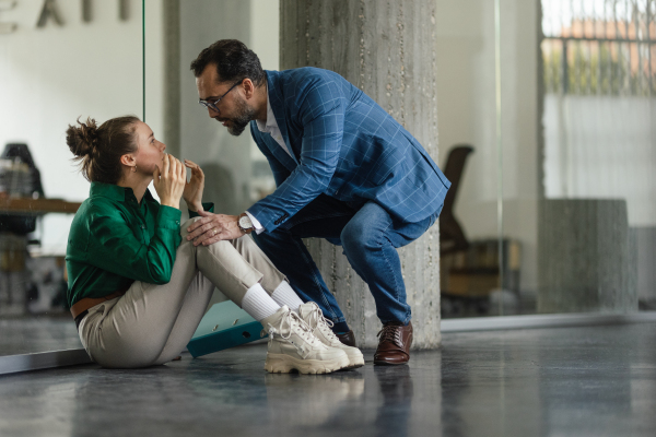 Mature man consoling his younger upset colleague.