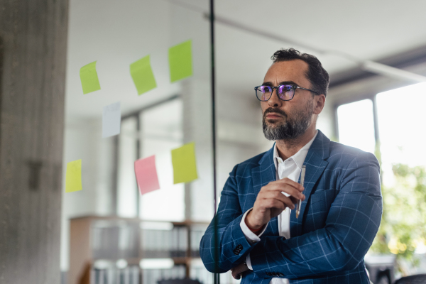 Businessman in suit taking notes in the office. Brainstorming, mind mapping techniques.