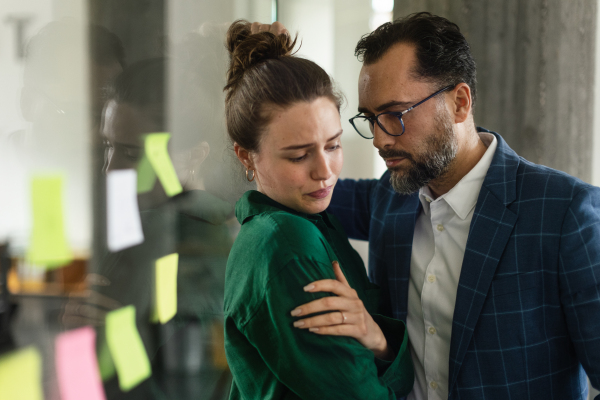 Mature man abusing his younger colleague, concept of harassment at work.