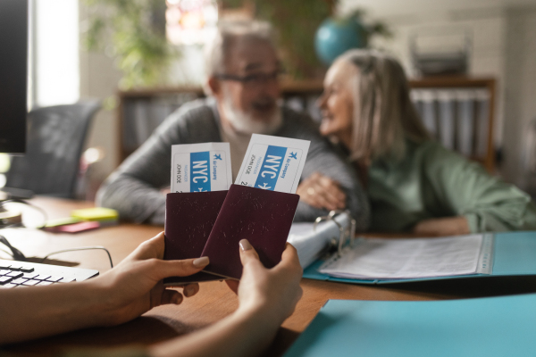 Close up of senior couple in travel agency making reservation for holiday.