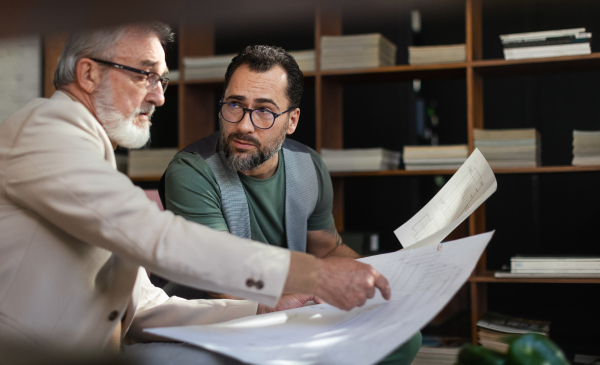 Young architect consulting project with a senior client. New architect getting advice from his senior colleague.