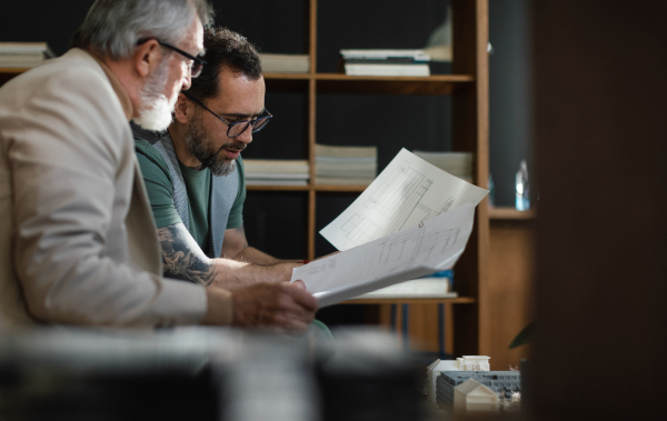 Young architect consulting project with a senior client. New architect getting advice from his senior colleague.