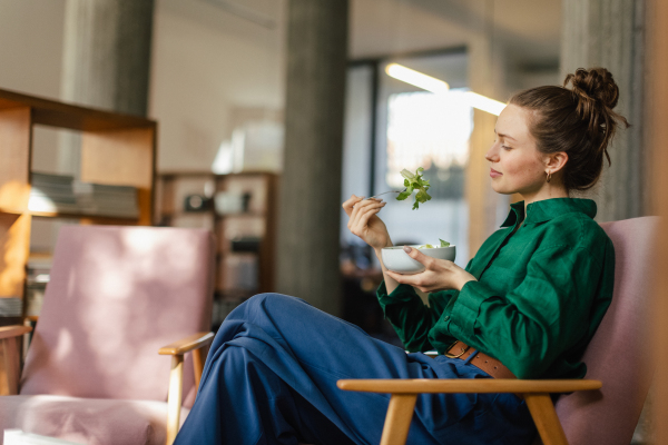 Young woman having lunch in the office.