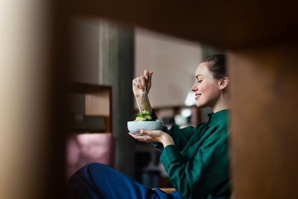 Young woman having lunch in the office. Eating healthy meal in the office.