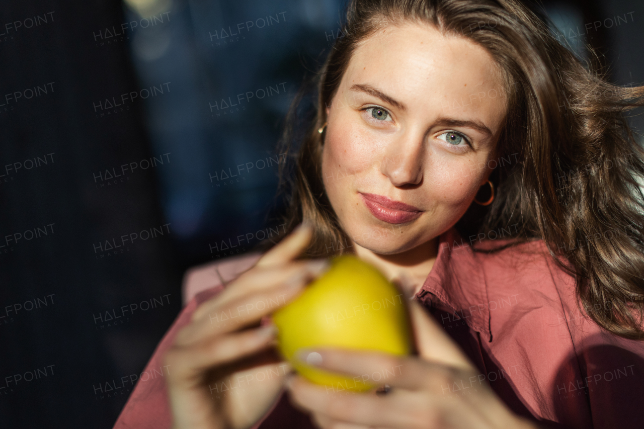 Portrait of young beautiful woman with apple.