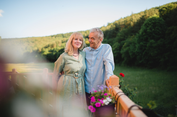 A portrait of affectionate senior couple spending time together in garden at home.