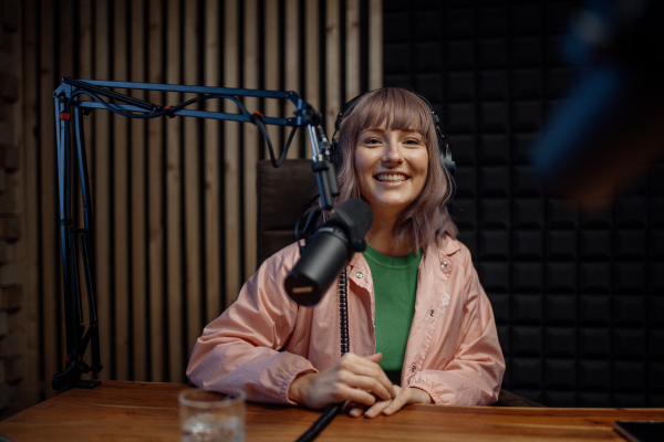 A portrait of female radio host speaking in microphone while moderating a live show