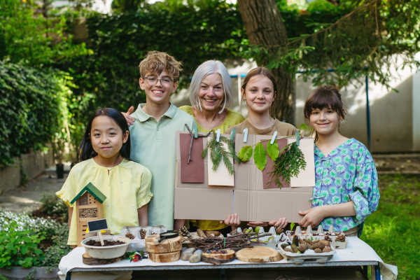 Portrait of students and female teacher at outdoor sustainable education class. Learning about nature, plants. Concept of experiential learning, ecoliteracy.