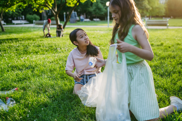 Students on nature walk picking plastic litter, environmental cleanup during outdoor sustainable education class. Concept of experiential learning, ecoliteracy.