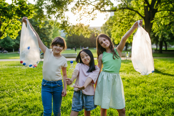 Students on nature walk picking plastic litter, environmental cleanup during outdoor sustainable education class. Concept of experiential learning, ecoliteracy.