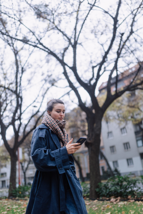 Young woman walking outdoor, in an autumn city.