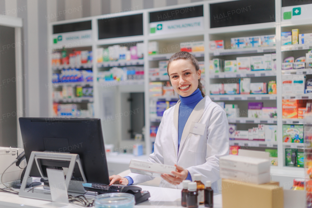 Portrait of a young pharmacist selling medication.