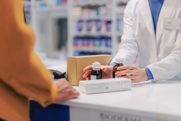 Close up of a pharmacist selling medications to the customer.